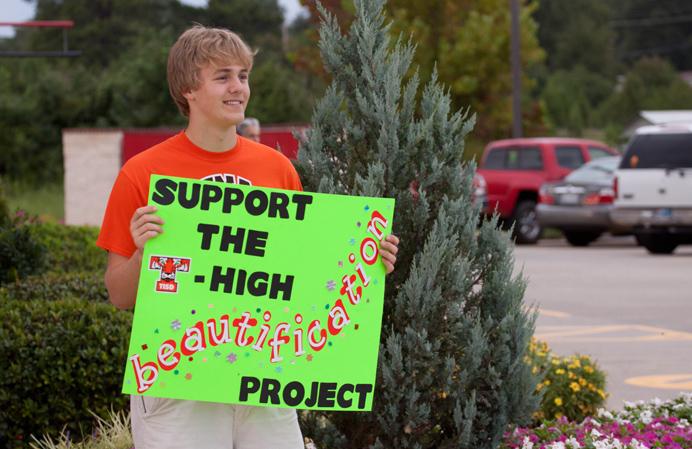 Senior Jacob Hill holds up a sign at Chicken Express to help TYTL with their fundraiser