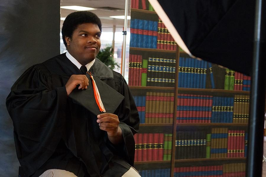 Senior Justin Lewis gets his cap and gown photo taken during the summer. Retakes will be Sept. 9.