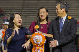 Senior Chau Dong, along with her parents, reacts to being named homecoming queen Friday at Grim Stadium.