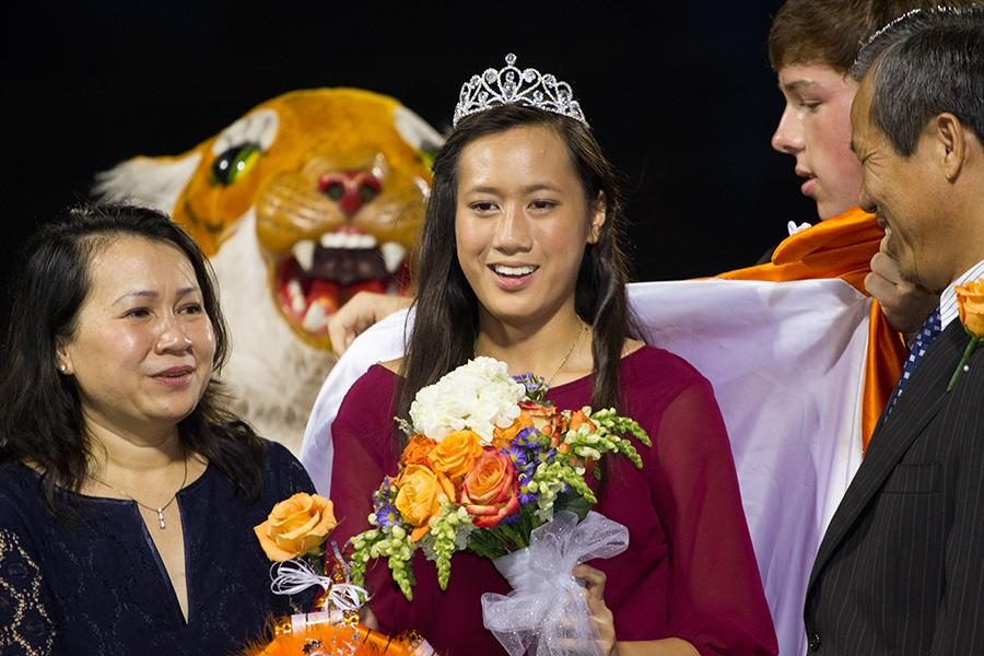 Surprised+to+be+named+homecoming+queen%2C+senior+Chau+Dong+stands+on+the+field+with+her+parents+Friday+at+Grim+Stadium.