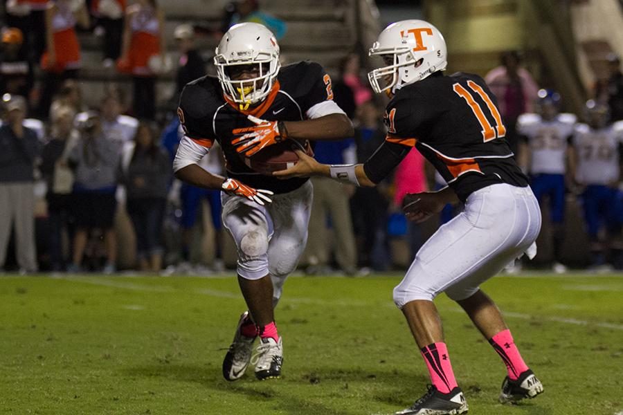 Senior quarterback Dakota Hunter hands the ball off to senior running back Treveon Walker.