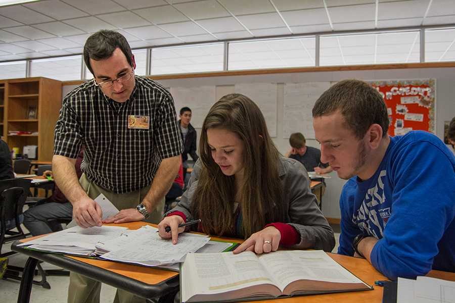 A new addition to TISD, teacher Jake Bickham assists seniors Carlie Clem and Zac Baker.