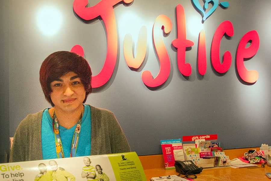 Behind the register, senior Johnny Mendoza-Watson works at Justice in Central Mall. Mendoza-Watson was promoted to Leading Brand Representative.