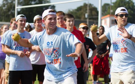 Sophomore Hutch Tidwell winds up to throw Principal Brad Bailey in dunk booth