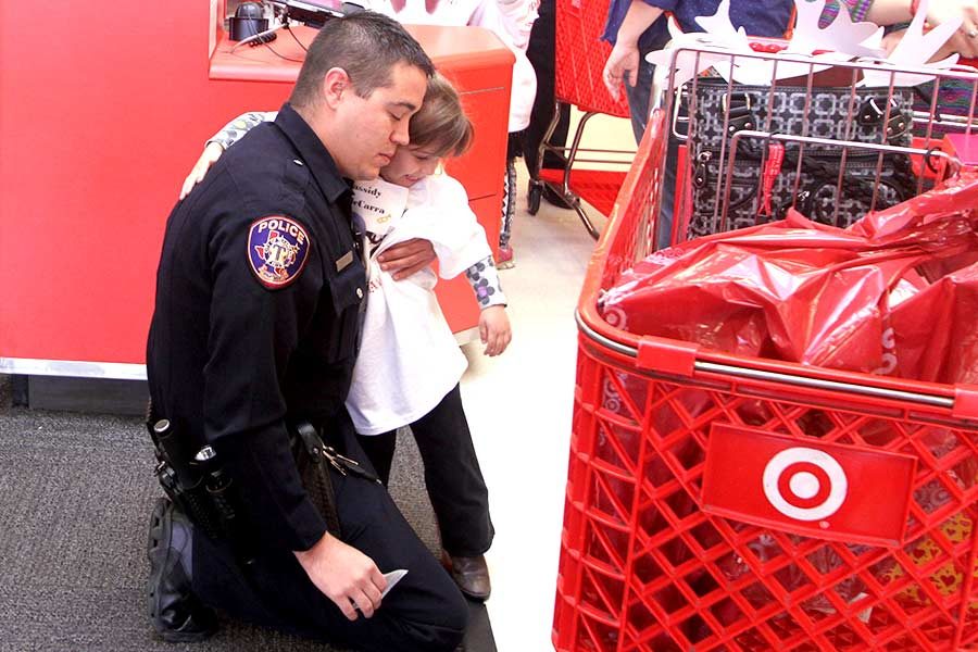 Officer hugs child participant in the event Heroes & Helpers goodbye as they finish a morning of shopping 