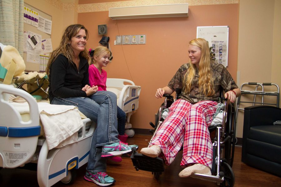 Madison Winchell sits with family in her room in the rehab facility at St. Michaels Hospital