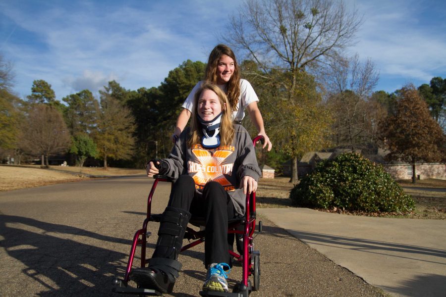 Paige Gibbert helps sister Lauren Gibbert by pushing her in a wheelchair