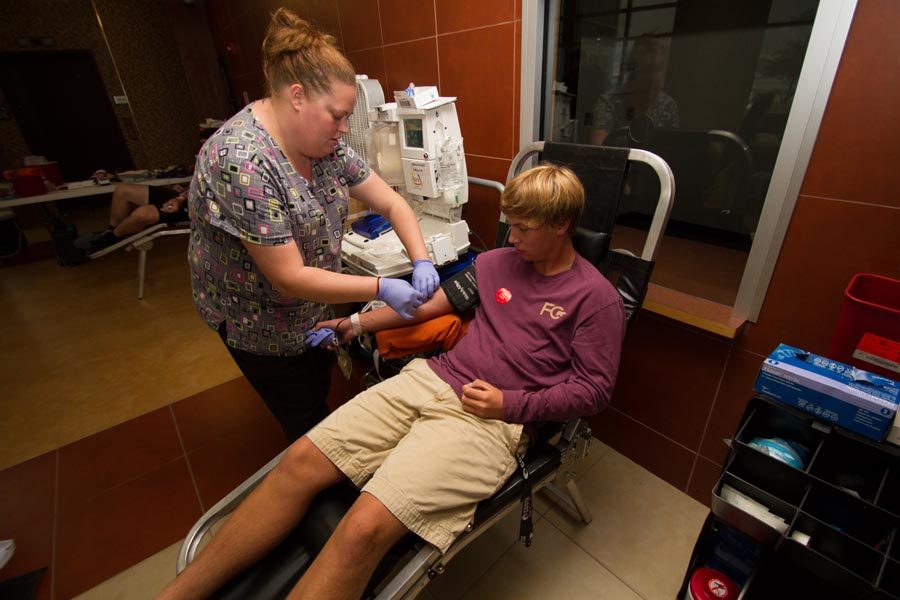 Junior Carson Romell donates blood during the October 2014 blood drive at Texas High School.