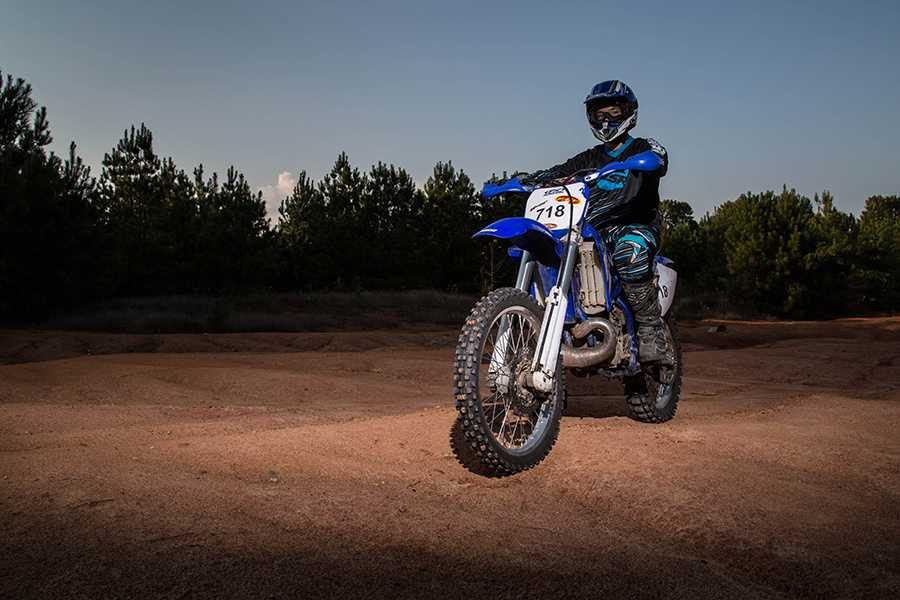 Darren Mooney poses with his dirt bike on a course he uses to practice for competition