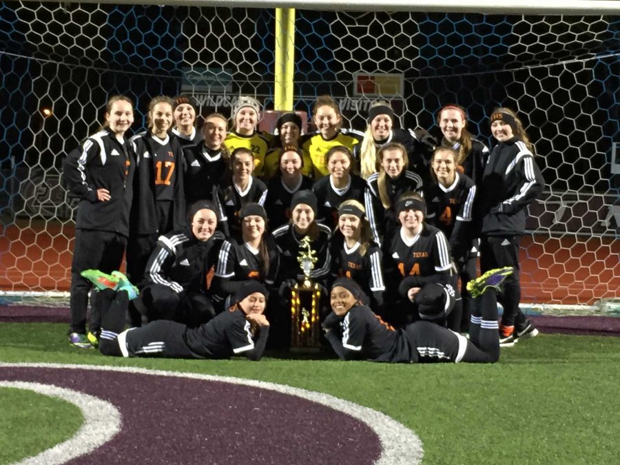 Varsity team stands with newly earned trophy from tournament