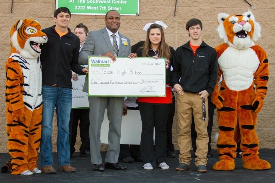 Gage Martin, store manager Anthony Porchia, Katie Johnston and Garett McDonald pose with grant given by the Neighborhood Market Walmart at store grand opening.