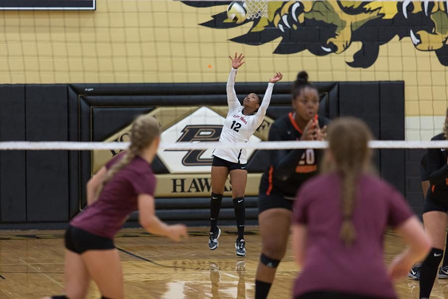 A lady tiger serves the ball over the net during a summer tournament at Pleasant Grove.