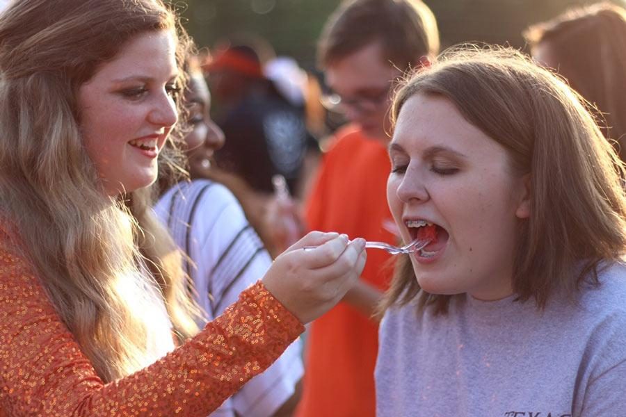 Juniors Olivia Johnson and Jillian Cheney, playfully enjoy watermelon. The annual Watermelon Supper was held the Saturday before school started.