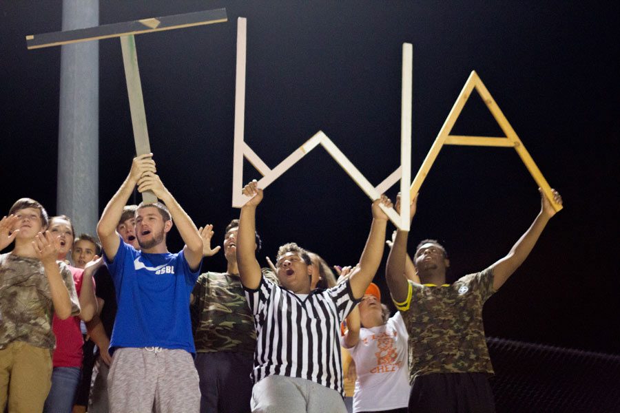 Seniors Colton Russell, Colby Gillespie and Jacoryon Larry hold T.W.A at the JV Football game against Arkansas High.