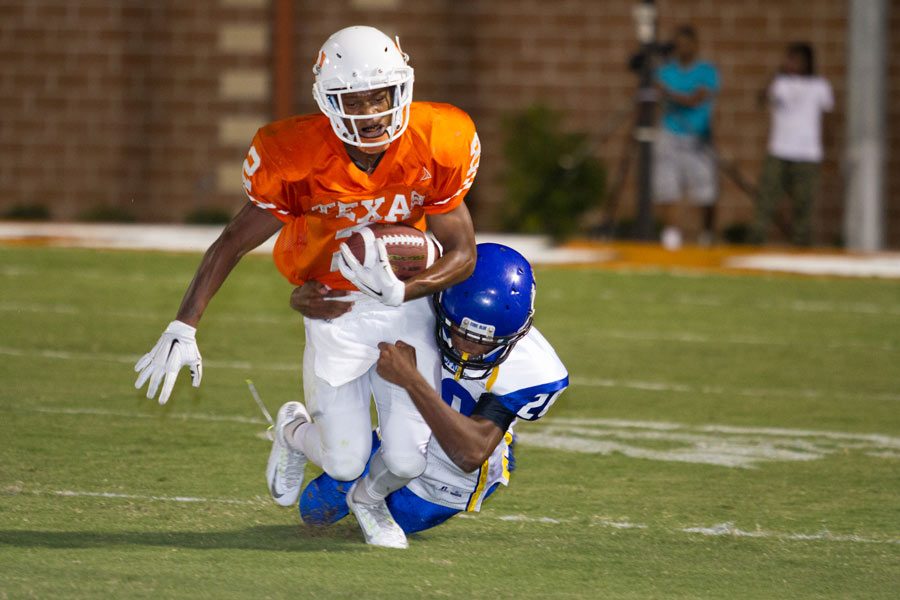 Junior Quan Hampton struggles to break free from a tackle. Tigers defeated the Wildcats 55-21 to open conference play. 