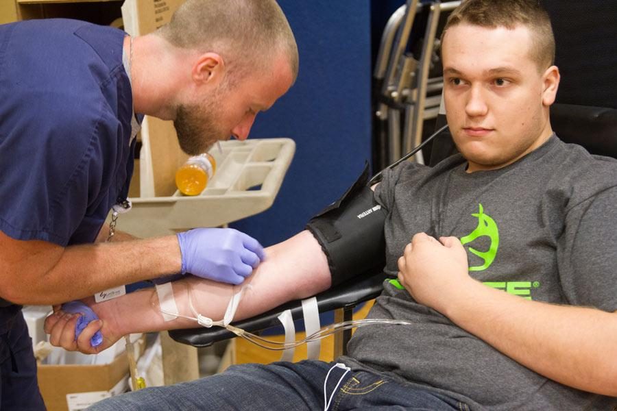 Senior Zane Moore relaxes and the United Blood Services technician prepares to tap his vein.