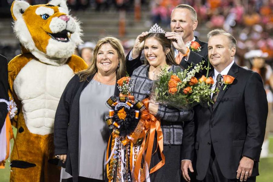 Principal Brad Bailey crowns Senior Anna Catherine Boudreaux as parents Tracy and David Boudreaux stand alongside. 