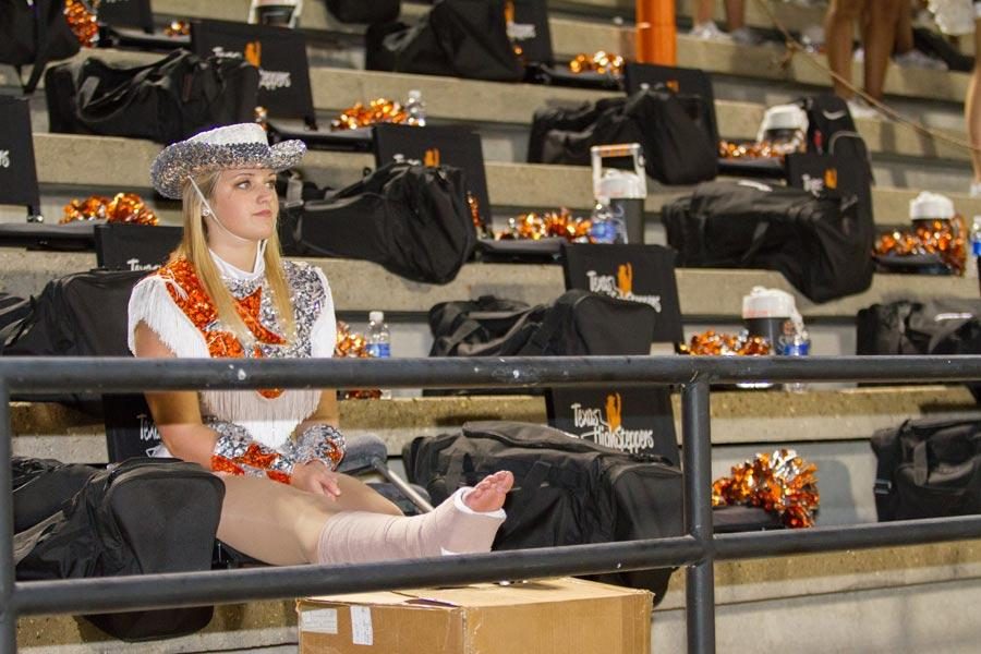 Senior Brooke Rayburn watches her fellow Highsteppers perform at a football game. Rayburn will be unable to dance until December.