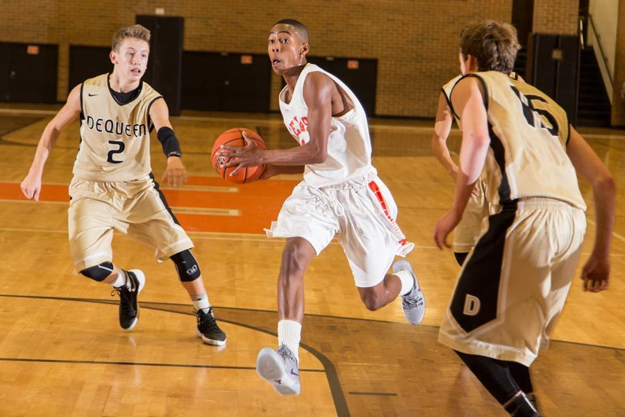 Guard R.J. Reid drives the lane against a host of DeQueen defenders in the first game of the 2015-2016 basketball season. 