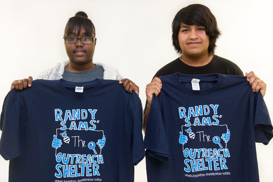 Junior Ketasha Noble and senior Adolfo Camacho proudly display the new Randy Sams t-shirts featuring their artwork.