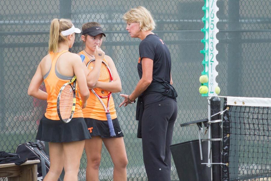 Coach+Anne+Tarwater+consults+with+senior+Aubree+Cramer+and+junior+Ali+Richter+during+their+doubles+match.