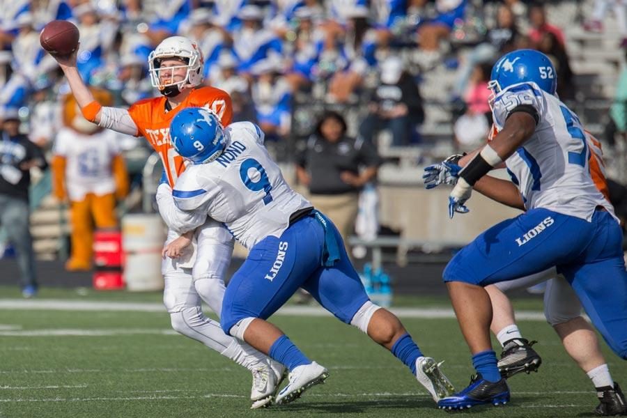 Texas High quarterback Cade Pearson is pressured by John Tyler defensive lineman Pierre Leonard. Texas High was defeated 48-21 ending the Tigers 2015 football season  with a record of 8-3.