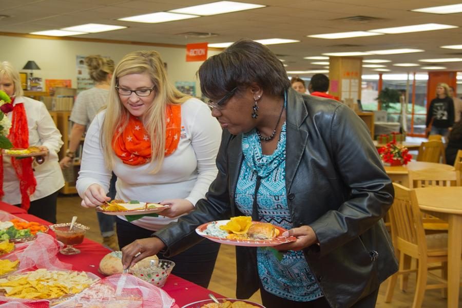 Mrs. Ashley Washington and Mrs. Tisha Gatewood fill their plates at the Rosebuds annual Teachers Tea.