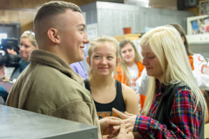 Airman Sawyer Spaulding holds his sister Piper's hand while his youngest sister Hartley beams with excitement after Spaulding surprised his sisters in his mother's classroom Thursday.