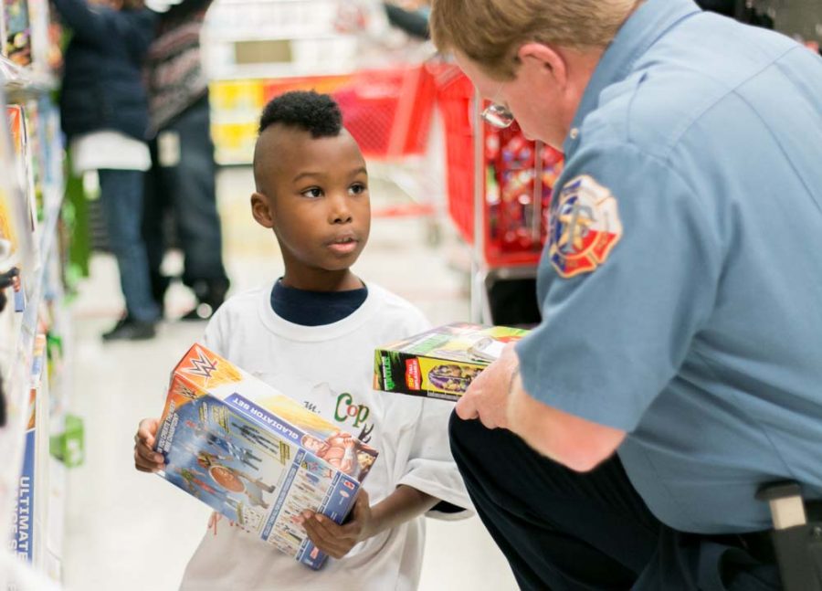 A Texas side firefighter helps one of the children selected to be part of Shop With A Cop and Firefighter at Target. Children selected for this event are given $100 to spend on whatever they want for Christmas.