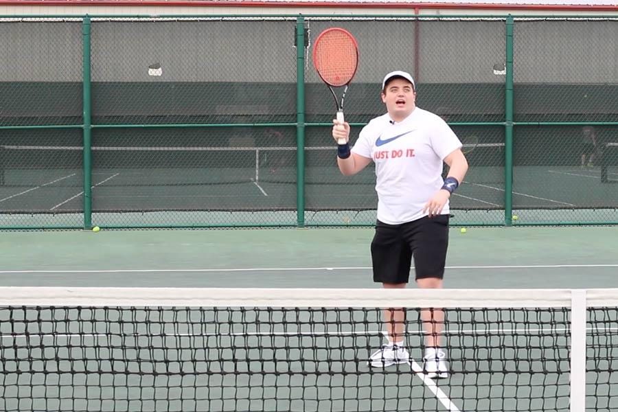 Junior Matt Francis prepares to hit a tennis ball. 