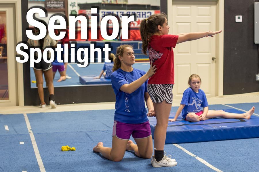 Senior Shaleigh Chandler spots one of her students as she prepares to do a back handspring. Chandler plans to become a physical therapist.