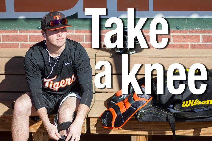 Senior+Trevor+Danley+watches+his+teammates+as+he+puts+on+his+knee+brace.+Ever+since+his+injury%2C+Danley+must+take+extra+precautions+when+it+comes+to+safety+during+sports.