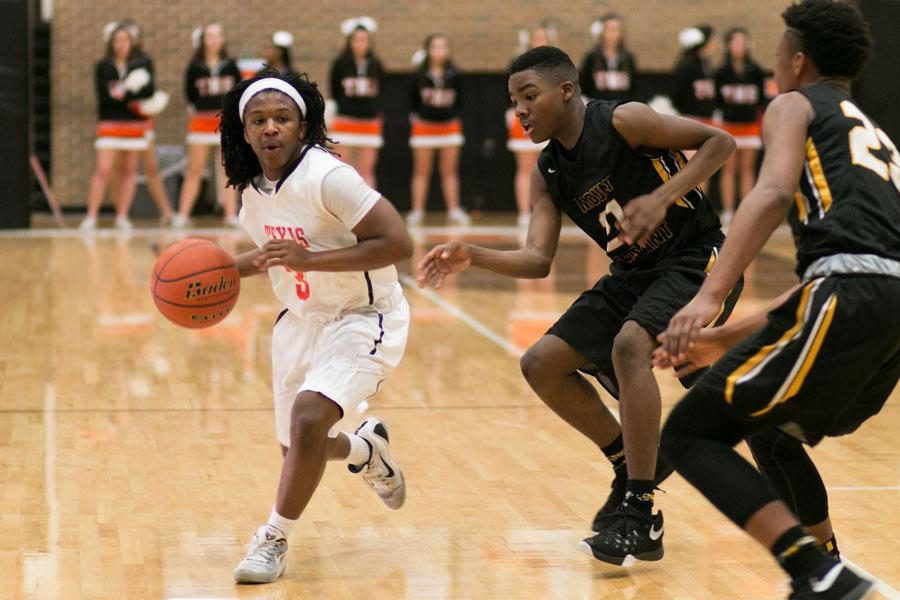 Texas Highs Vonderic Stanley attempts to dribble past Mt. Pleasants defenders.