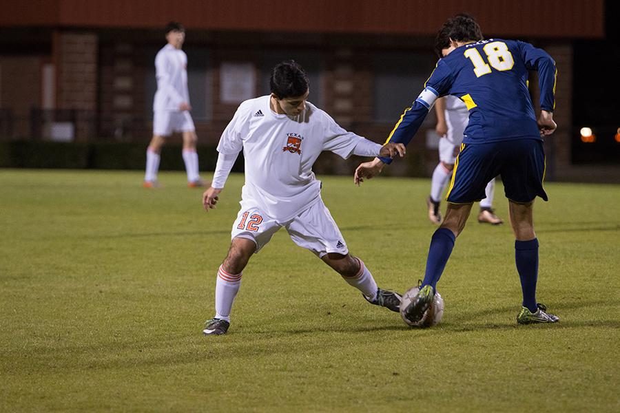 Junior Alejandro Hernandez dribbles the ball past a defender. 