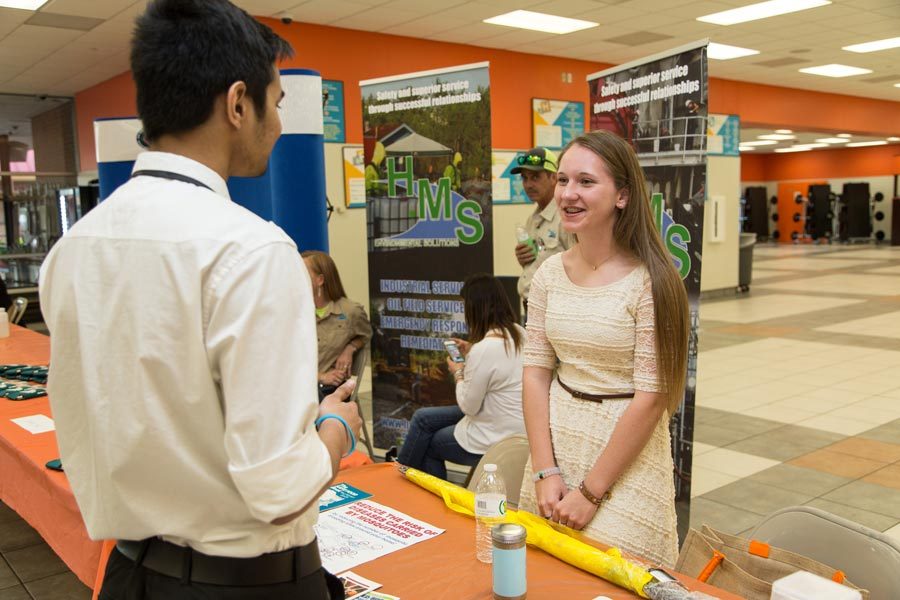 Junior Rachael Shewmaker presents her business to a student at the Environmental Expo.