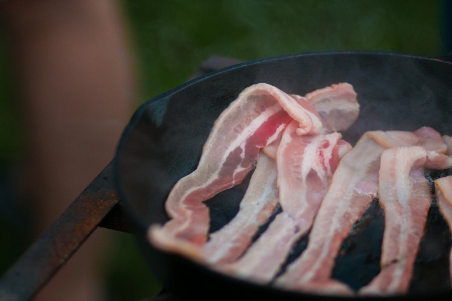 Freshly placed bacon sizzles in a pan on the morning of the annual bacon fry. The morning before the Texas vs. Arkansas game seniors gather to prepare breakfast for the student body.