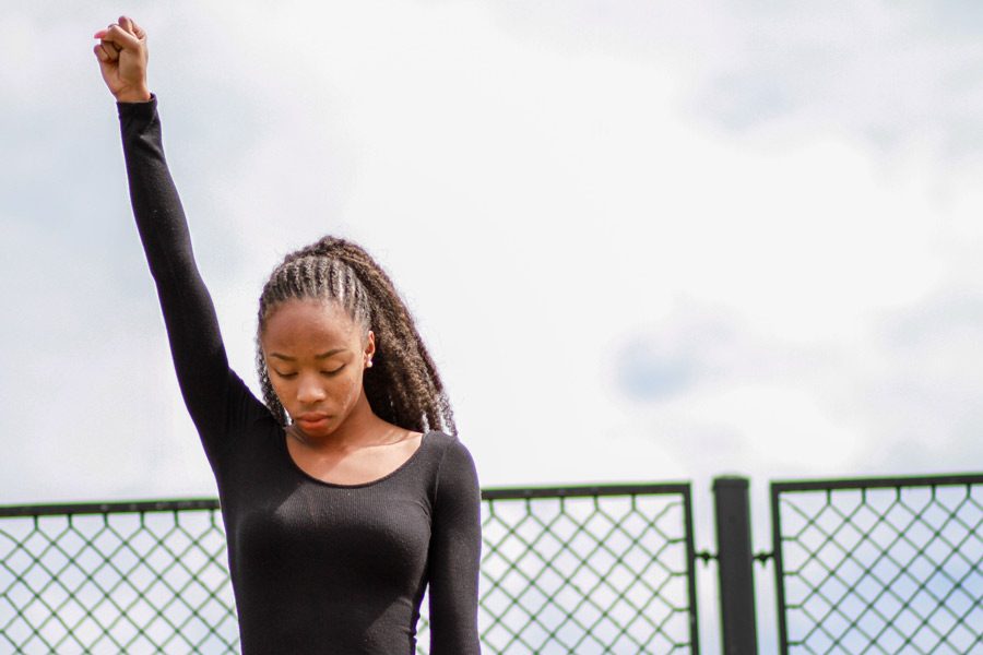 Senior Ohemaa Barnes raises a fist, echoing the Black Power movement of the 60s. Barnes aroused controversy when she kneeled during the national anthem Saturday morning.  