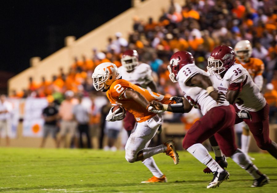 Receiver Quan Hampton pulls away from the defenders during the Texas vs. Arkansas game. The Tigers defeated the Razorbacks 37-7.