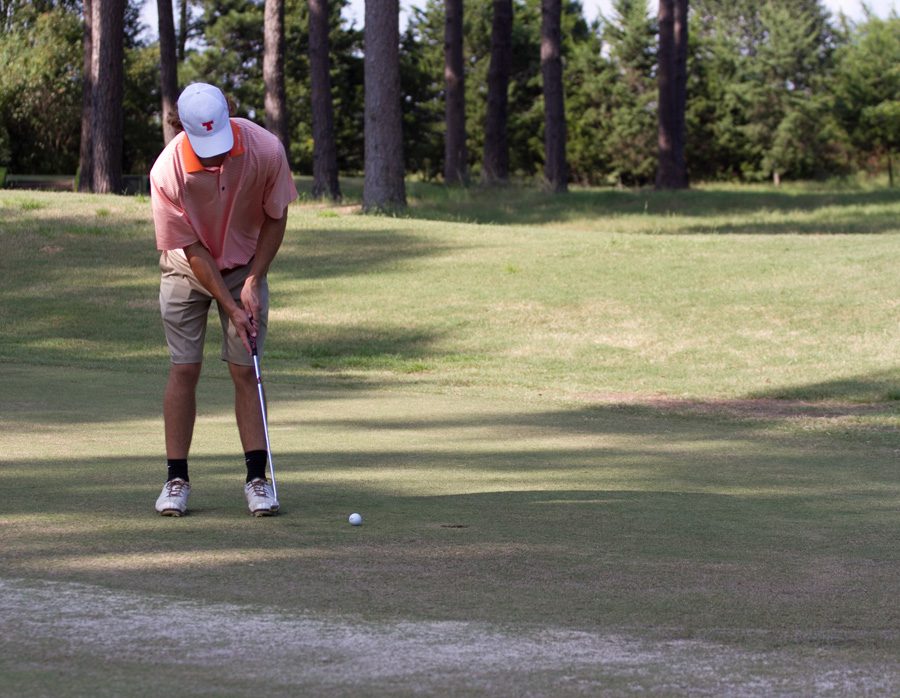 Senior Alex Davis putts the ball during the City Golf Tournament. The Varsity Boys golf team competed in the tournament on September 14.