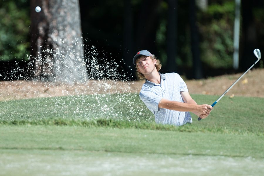 Junior Matt Prieskorn chips his ball out of a sand trap during the Tiger Classic golf tournament. The tournament took place on Sept. 30 and Oct. 1.