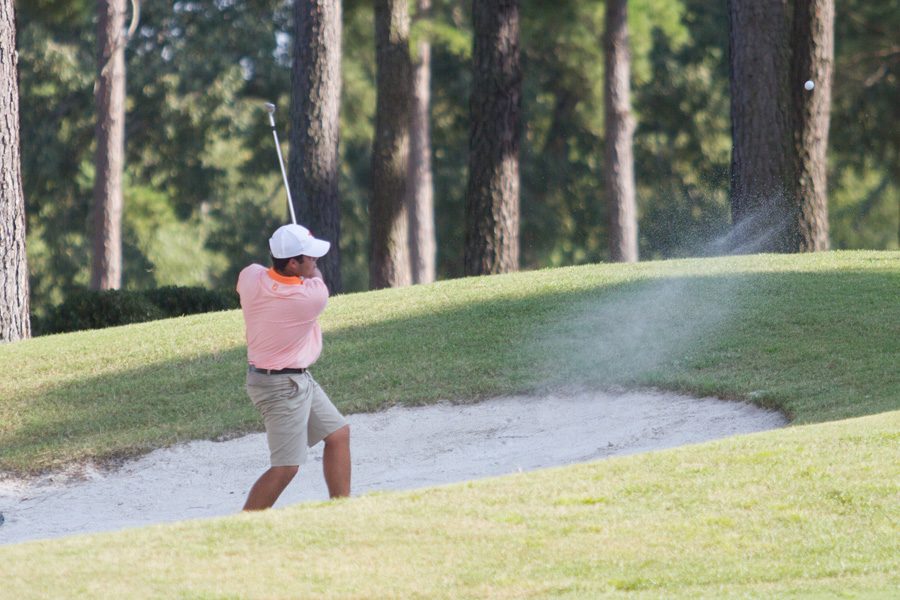 Senior Zayne Madden hits a ball out of the bunker. The Varsity Boys golf team competed in the City Golf Tournament on September 14.