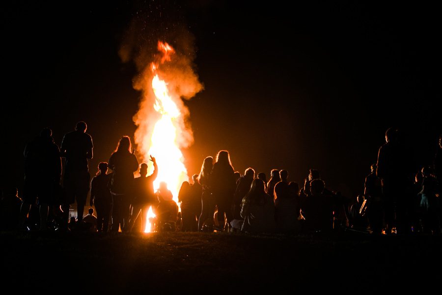 Flare rise above the student body as they sit on the Hill behind the Texas High School Multipurpose Building. The bon fire is a celebration of the football teams advancement into the playoffs.
