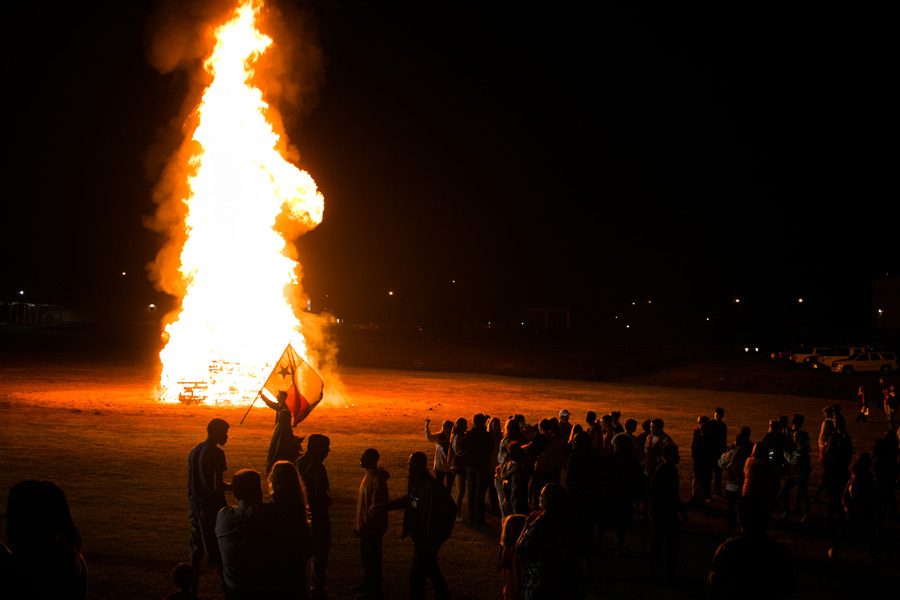 Senior Tye Shelton parades the Texas flag in front of the crowd at the first playoff game bonfire and pep rally. Texas High will play West Mesquite Friday Nov. 11, 2016 in the first round of the playoffs.