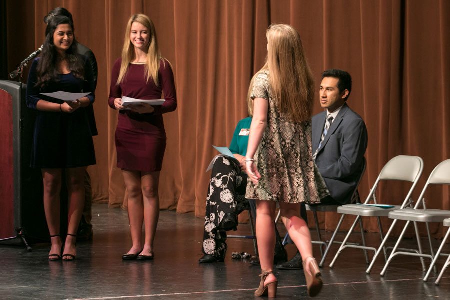 President Raga Justin and Vice President Ali Richter wait to award sophomore Sarah Grace Boudreaux with her certificate of membership.