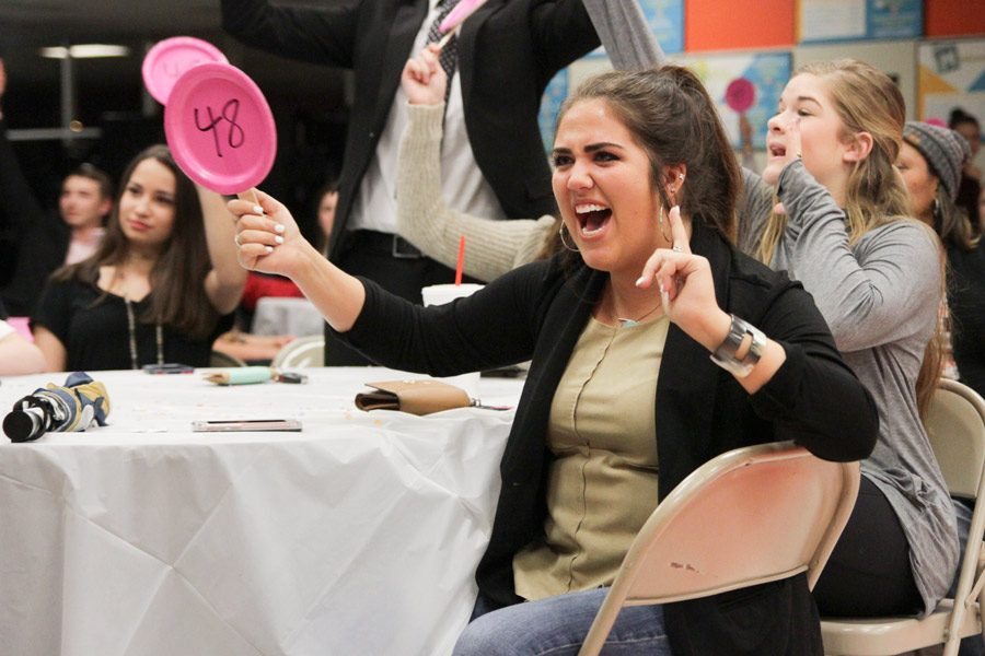 Senior Marjorie Slimer enthusiastically bids on a bachelor. The Bachelor Auction was held Feb. 20.