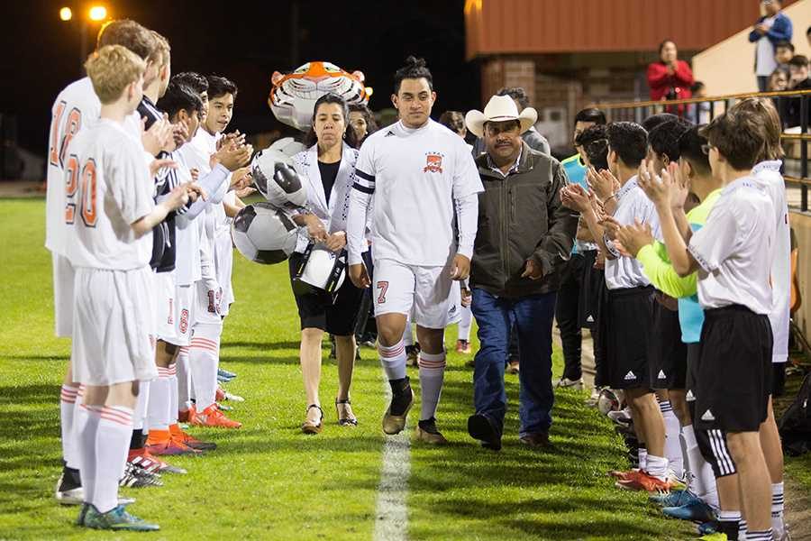 During the boys soccer senior night, senior Isidro Hernandez walks out with his family. 