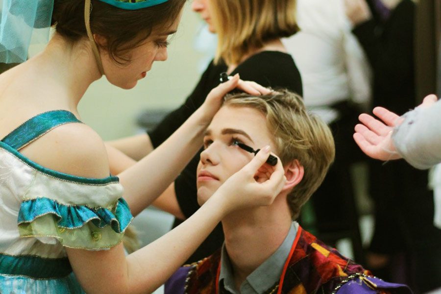 Junior Colton Johnson receives help from senior Grace Hickey with putting on his stage makeup. Johnson played the role of Pascal in “The Axeman’s Requiem.” Photo by Odin Contreras