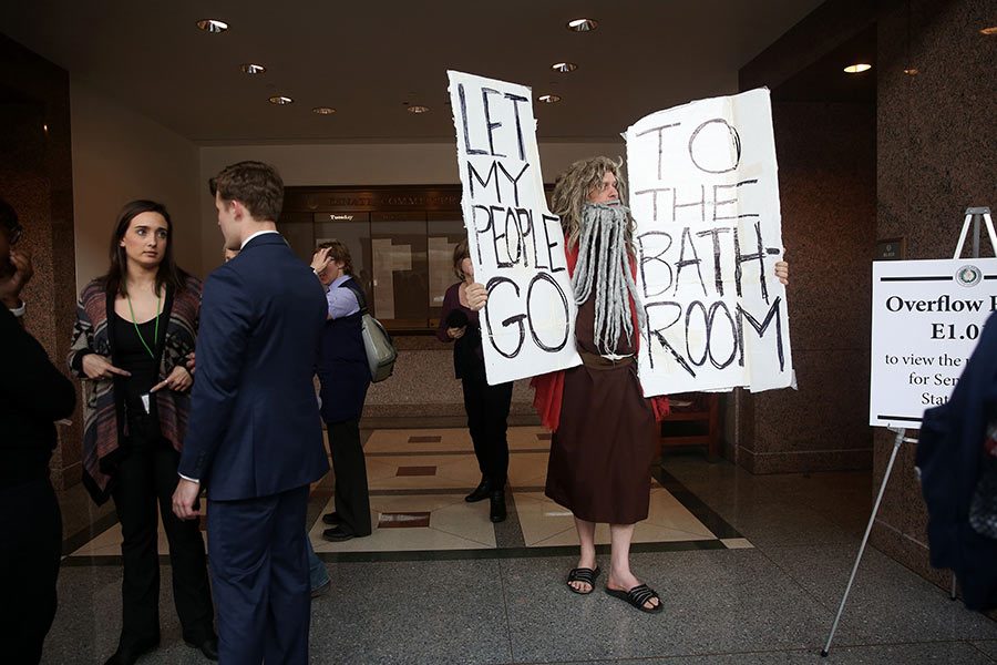 John Erler, dressed as Moses, holds signs as members of the Senate State Affairs Committee debate and hear public testimony over Senate Bill 6, the transgender bathroom bill, on Tuesday, March 7, 2017 at the Texas State Capitol in Austin, Texas. The bill would require transgender Texans to use public restroom facilities that match their birth gender. (Rose Baca/Dallas Morning News/TNS) 