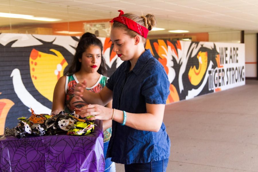 Meredith Maynard (12) passes out goodie bags during the NHS Halloween event.