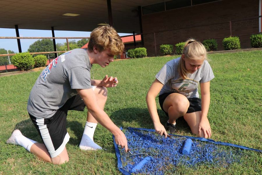 Sophomores Jackson Cheney and Sarah Lingle work together to paint the pit, which is located outside the cafeteria.